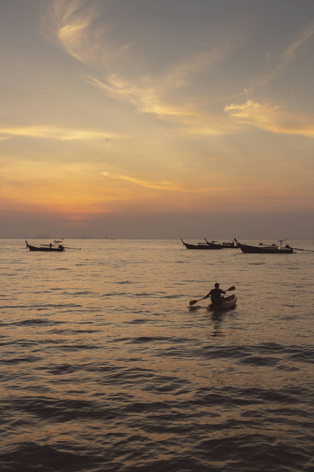 Silhouette von Menschen, die während des Sonnenuntergangs auf dem Boot fahren