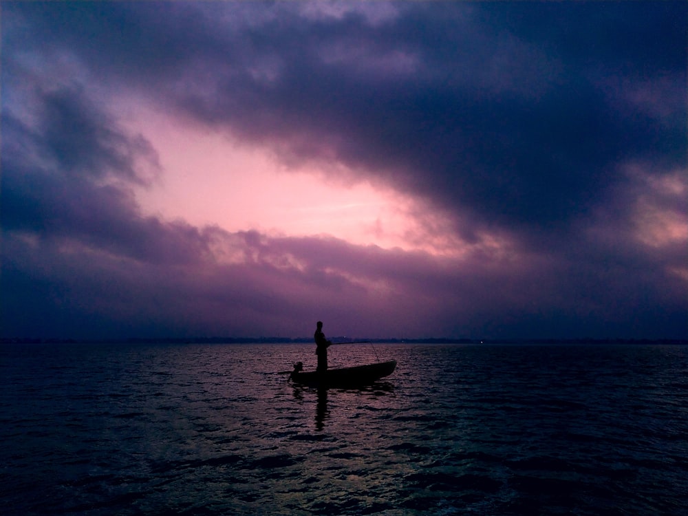 silhouette of person on boat during sunset