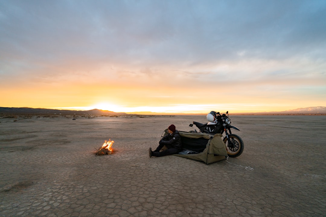 black and white motorcycle on beach during sunset