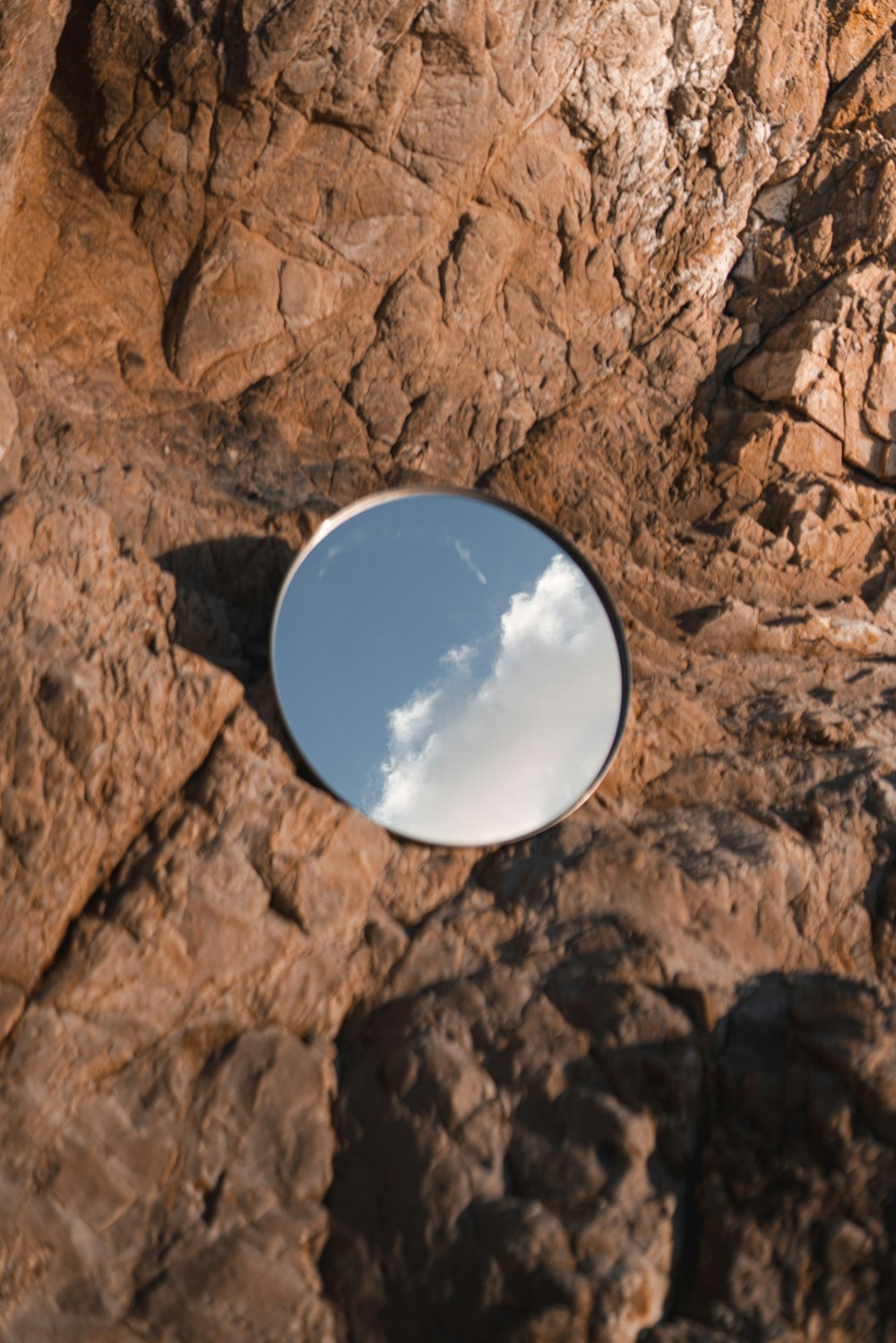 blue and white round ornament on brown rock