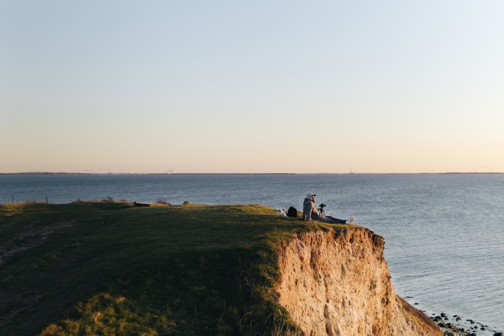 personnes sur la falaise près de la mer pendant la journée