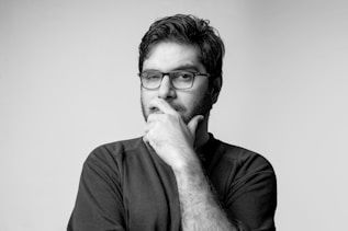 man in black long sleeve shirt wearing black framed eyeglasses