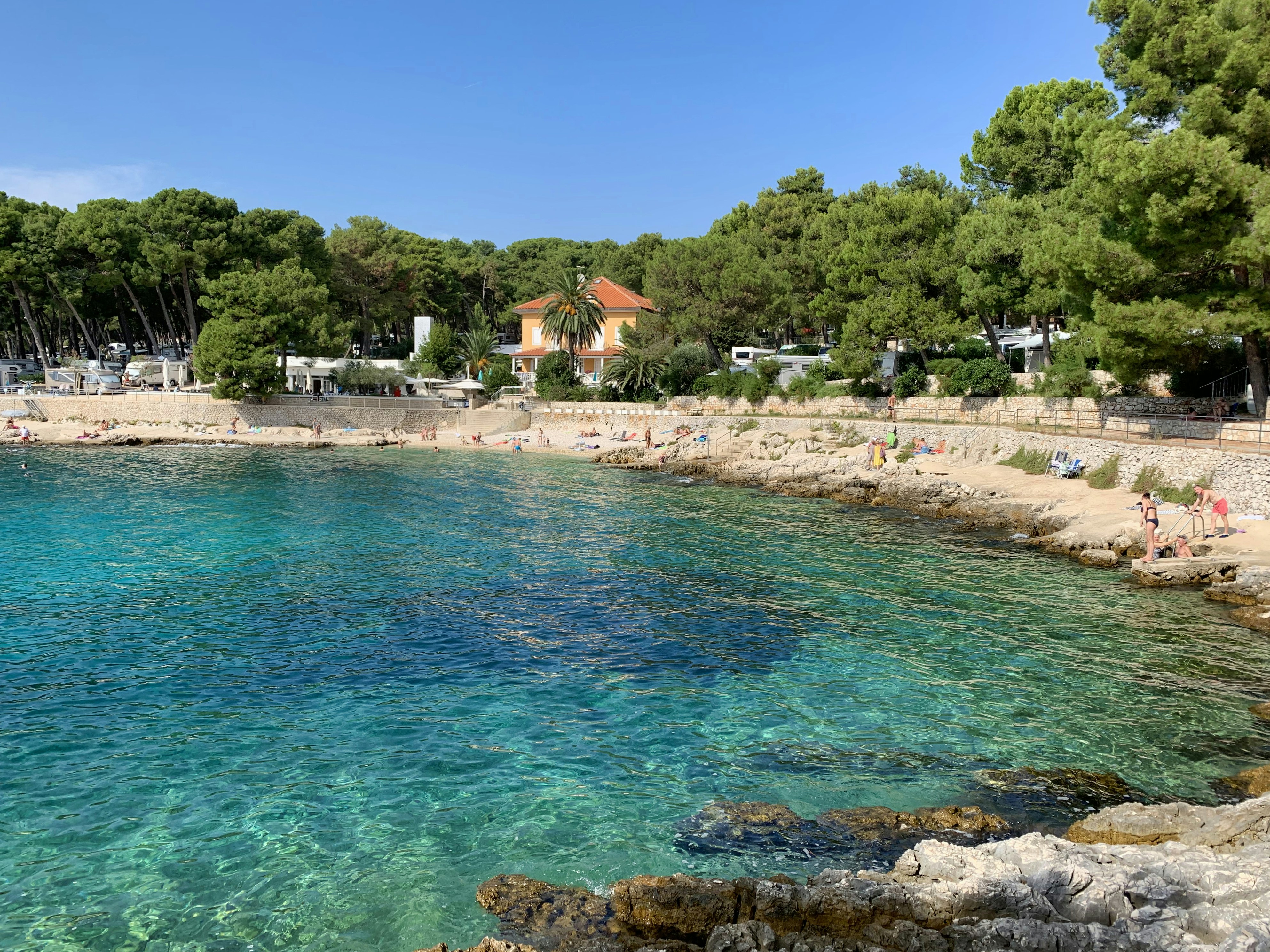 a body of water surrounded by trees and people, Lovely beach sight in Primorje-Gorski Kotar.