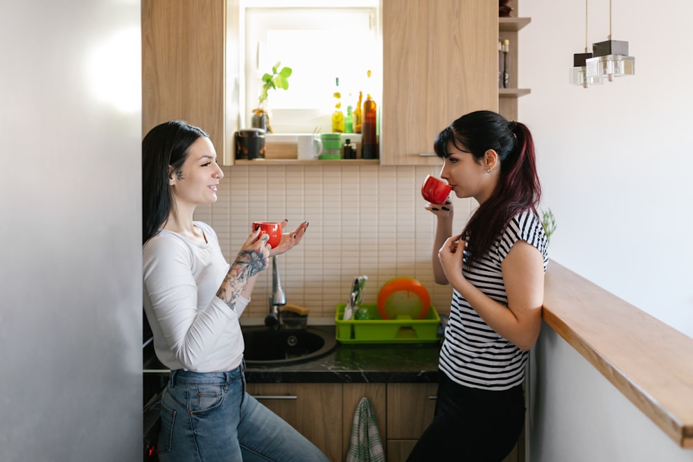 woman in black and white striped shirt holding red ceramic mug