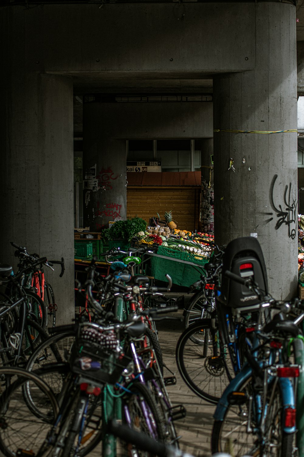 bicycle parked beside wall with vegetable display