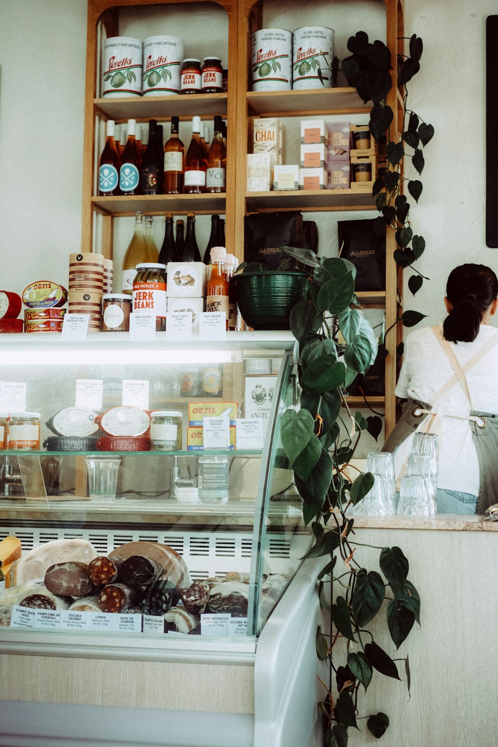 man in white shirt standing near glass shelf