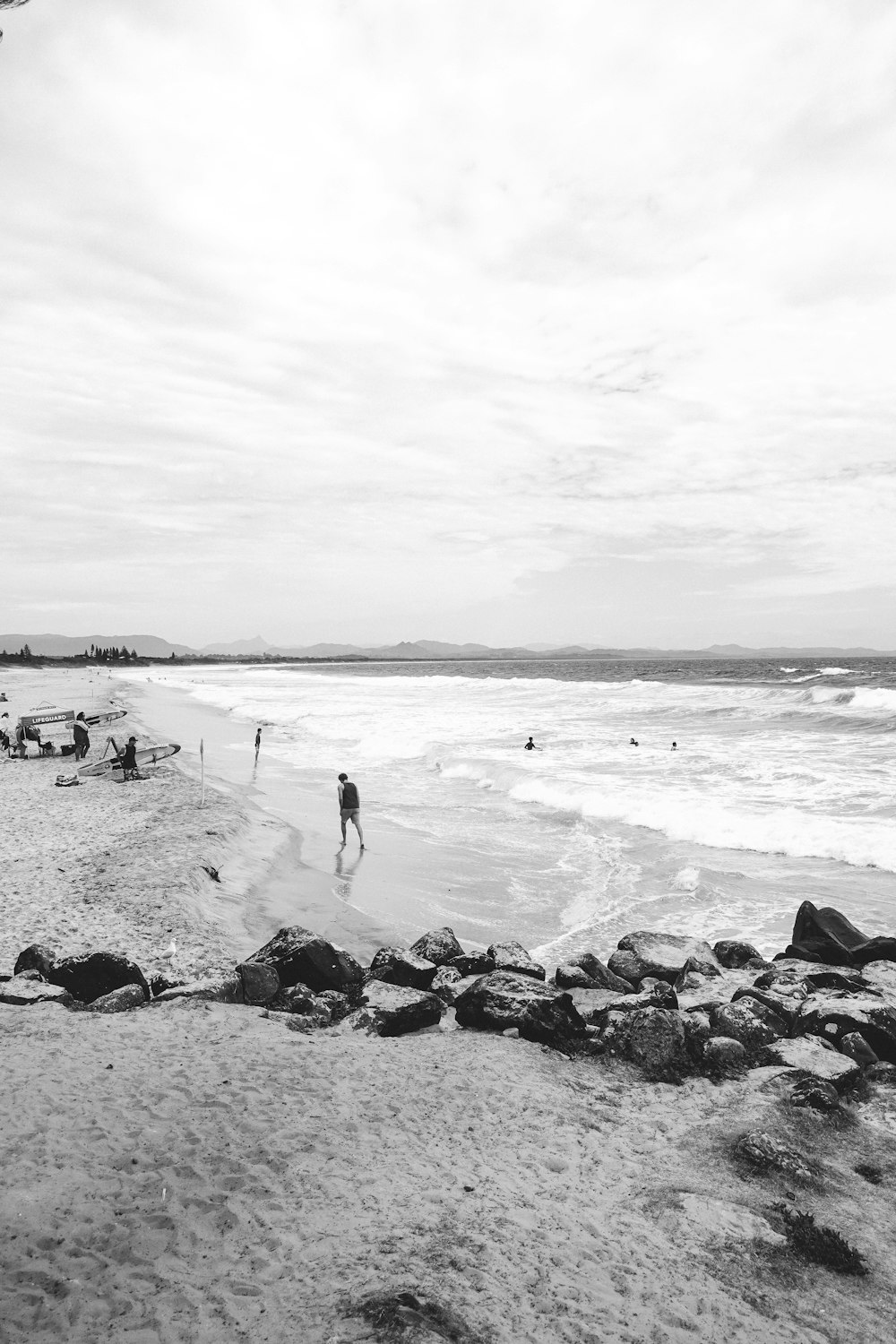 grayscale photo of people on beach