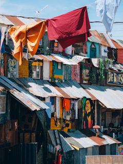 red textile hanged on brown wooden house during daytime