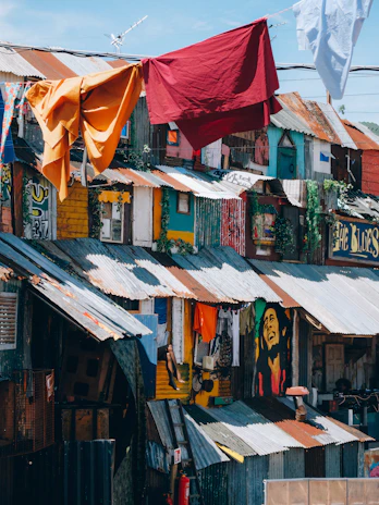 red textile hanged on brown wooden house during daytime