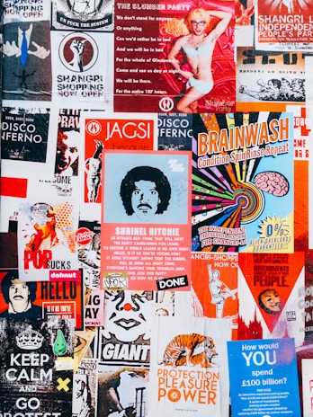 A vibrant collage of posters with various colors and designs. The posters feature a mix of artistic illustrations, bold typography, and playful graphics. There are themes of independence, entertainment, and political statements with a retro vibe.