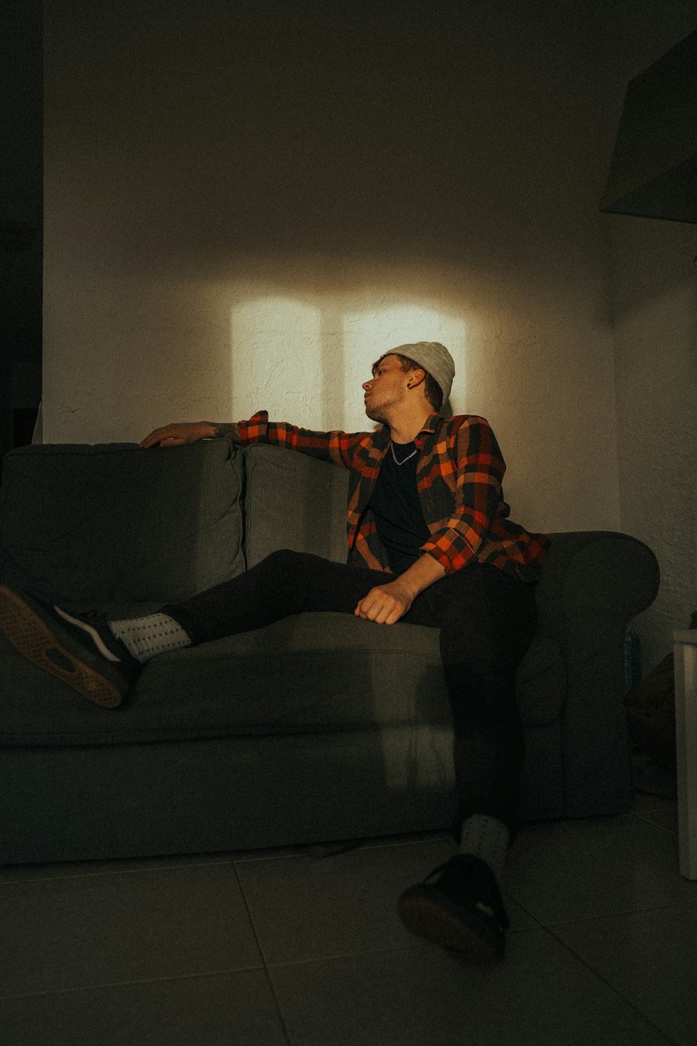 man in red and white plaid dress shirt sitting on black couch