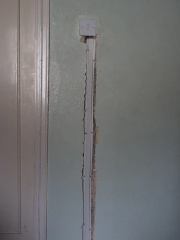Electrician installing wiring inside a modern home wall