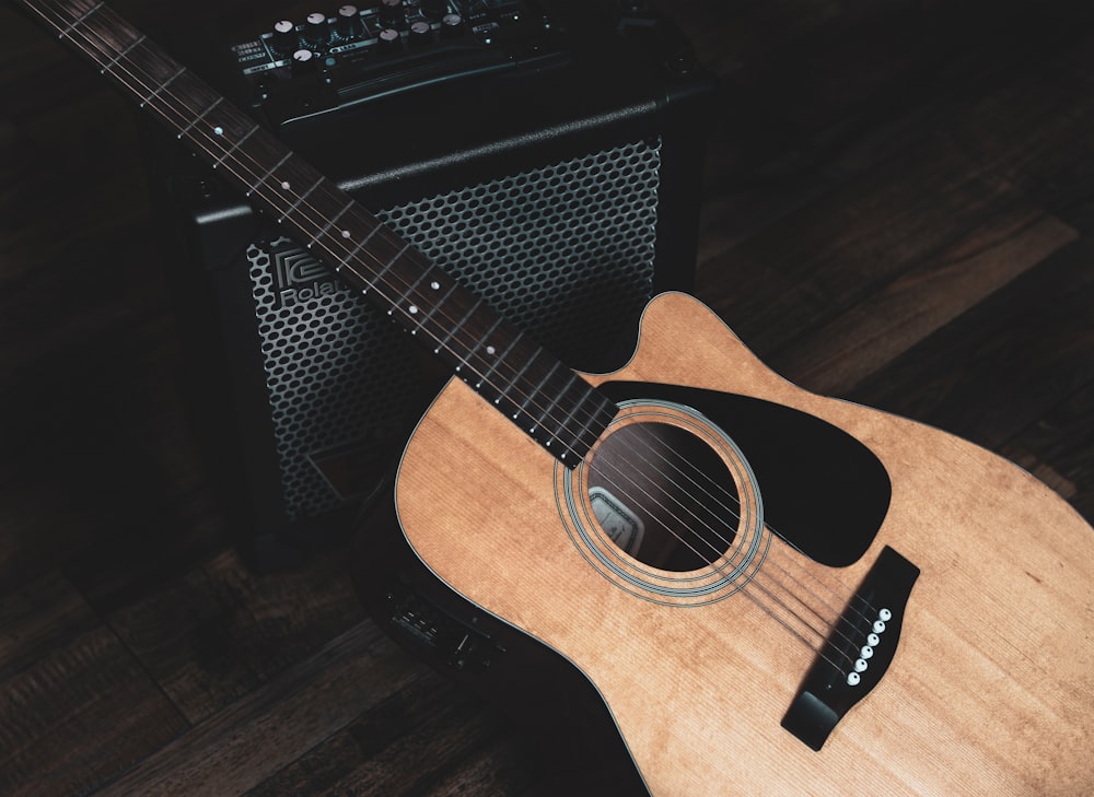 brown acoustic guitar on black guitar case