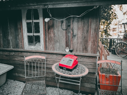 A rustic wooden table with a vintage telephone and a notepad, symbolizing warm and personal communication.