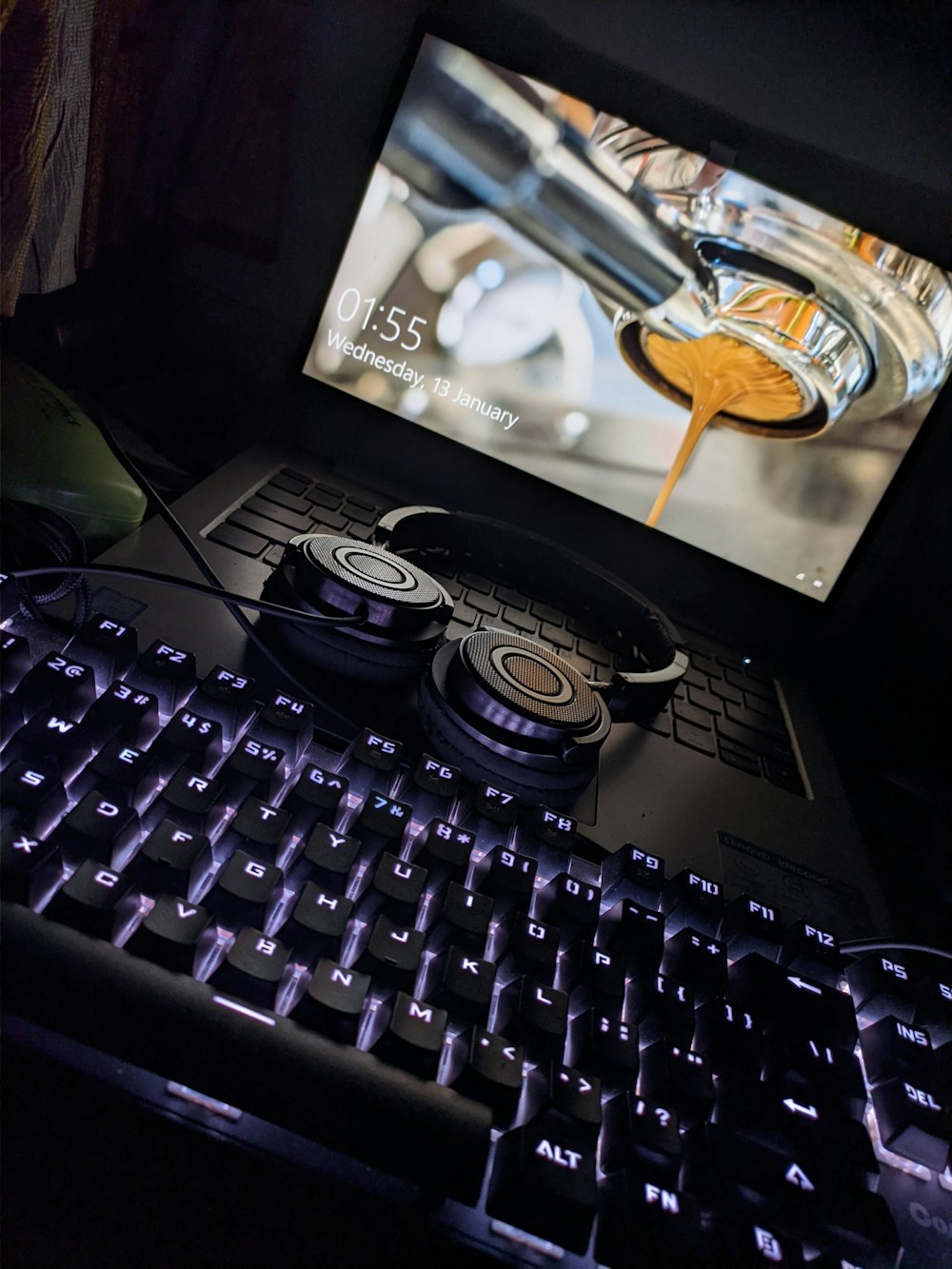 black computer keyboard beside black and silver headphones