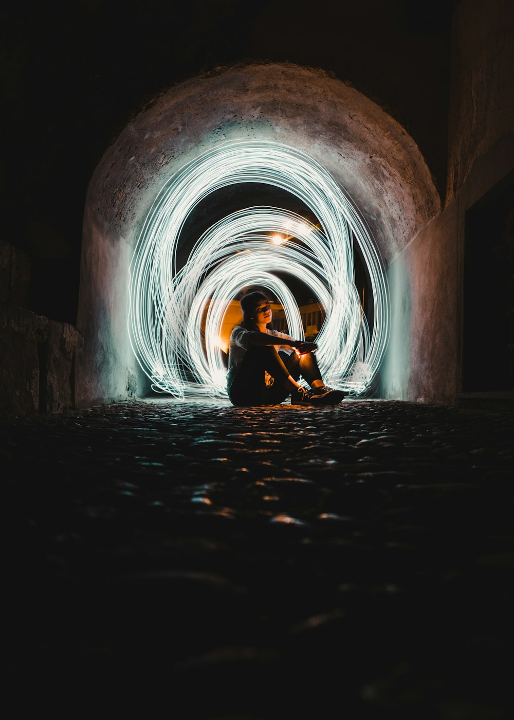 man in black jacket sitting on tunnel