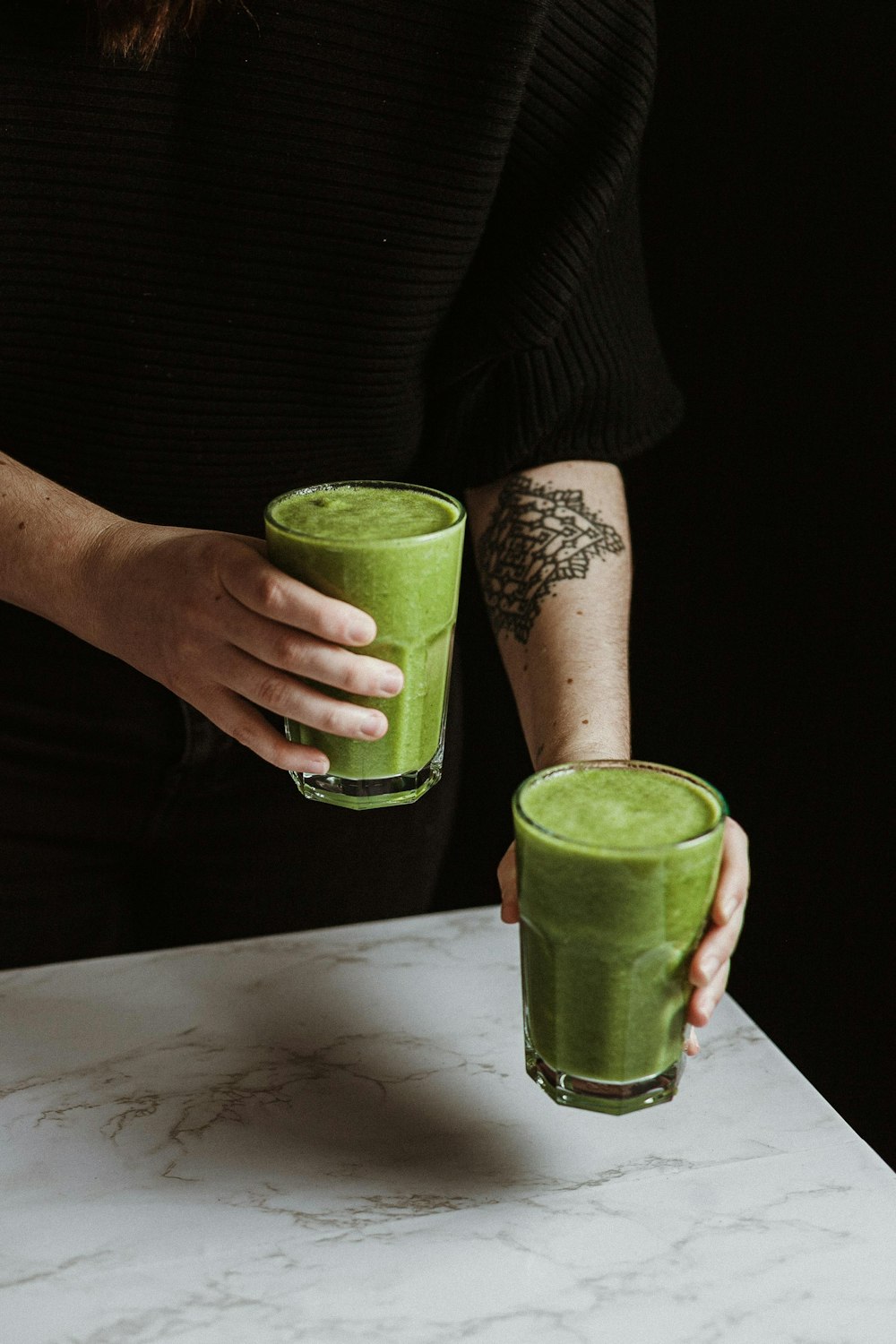 person holding green drinking glass