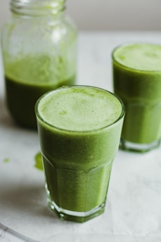 green liquid in clear drinking glass