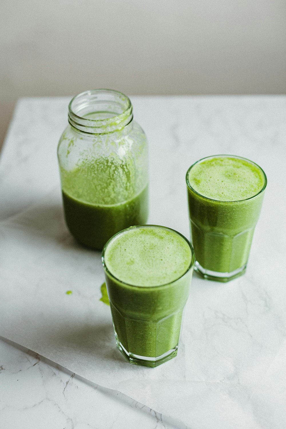 two clear glass jars with green liquid