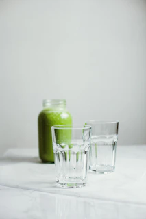 Natural light illuminating jars of mixed nutrition powders with soft cream and green accents in the background