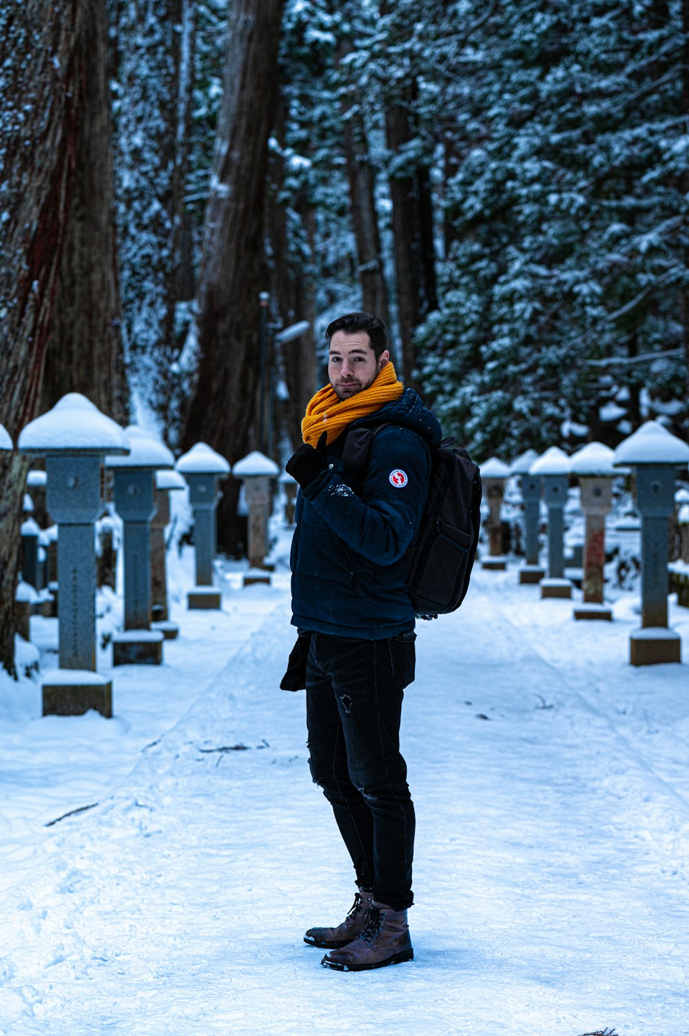 woman in black jacket and black pants standing on snow covered ground during daytime