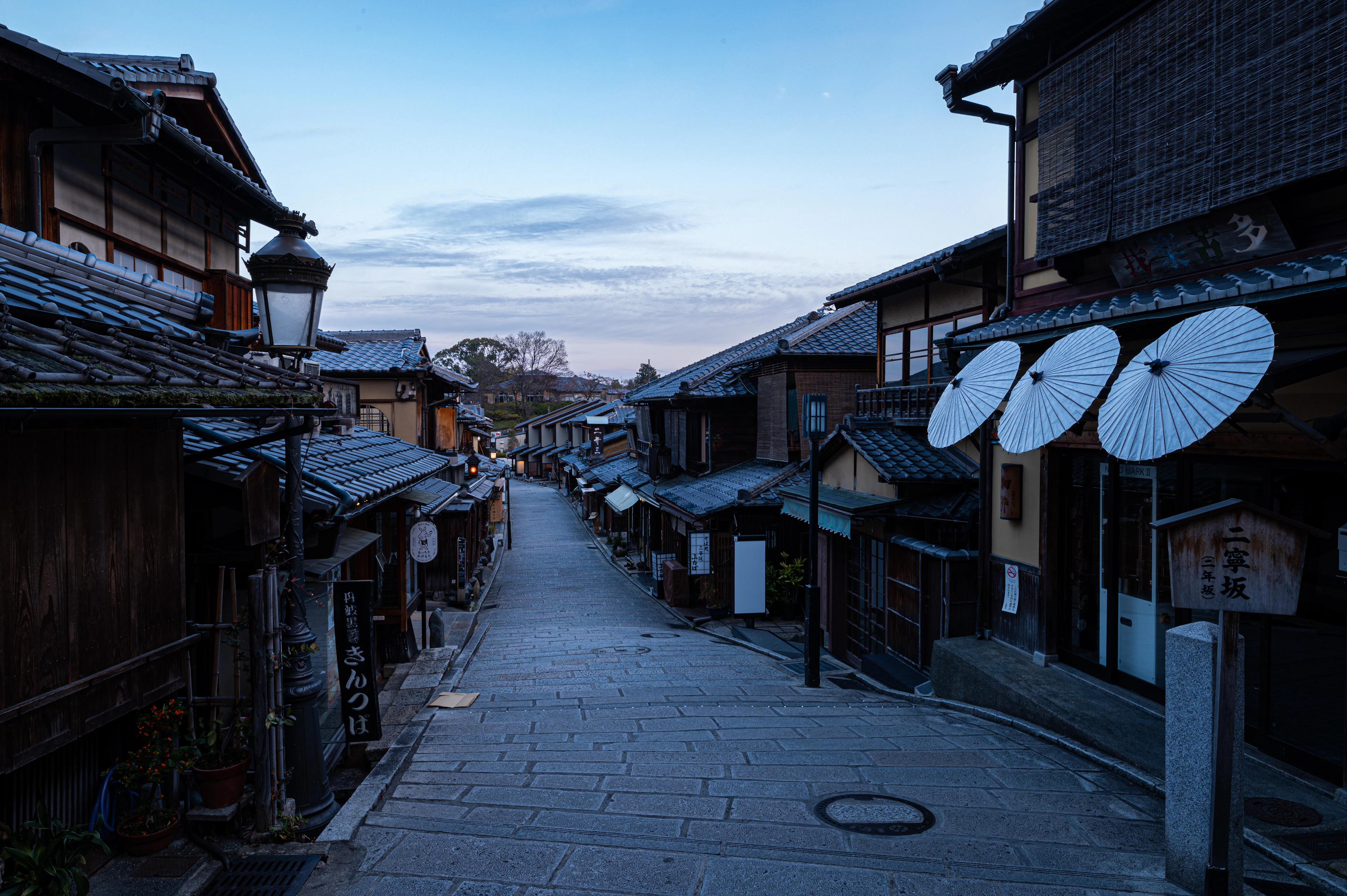 An empty stone-paved lane between wooden houses in the early morning, Kyoto