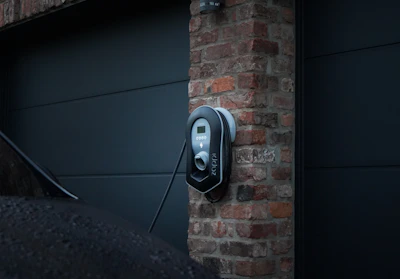 A modern electric car charging at a home station