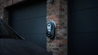 Residential EV charger mounted on a modern home garage wall with cyber lime lighting highlights.