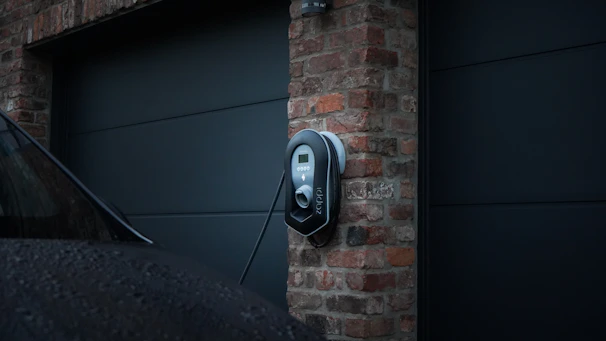 Technician setting up an electric vehicle charging station outside a residential home.