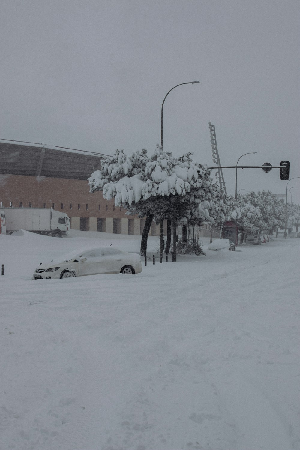 snow covered cars parked on snow covered road during daytime