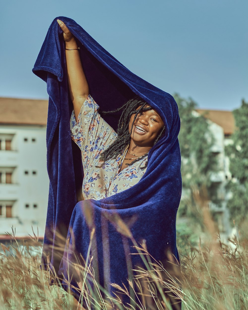 woman in purple hijab standing on brown grass field during daytime