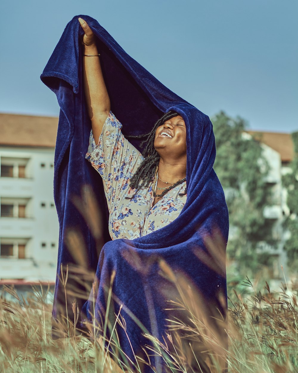 Frau im blauen Hijab steht tagsüber auf grünem Rasen
