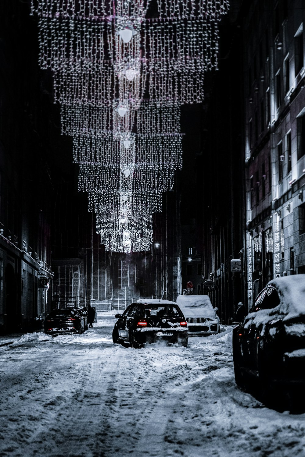 black car on road in between high rise buildings during daytime