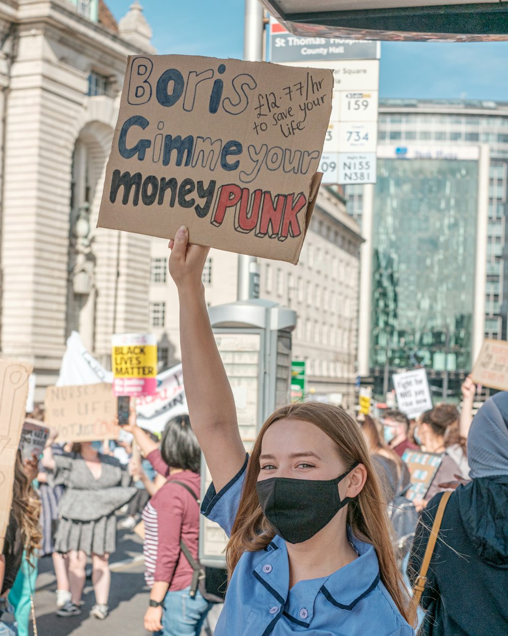 woman holding white and blue happy birthday signage