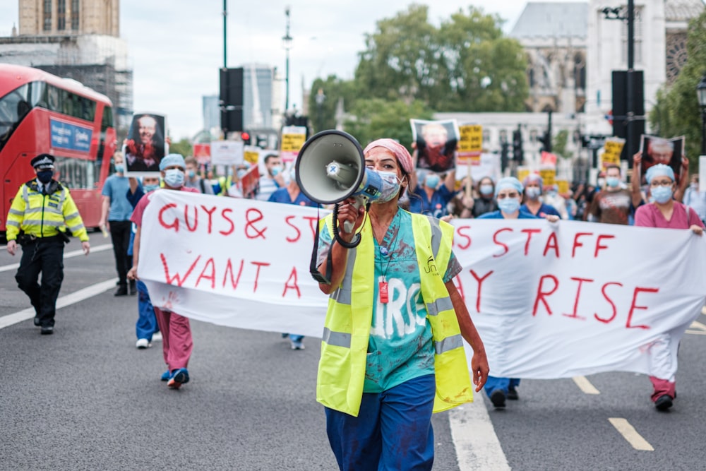 man in yellow and green suit holding white and red banner