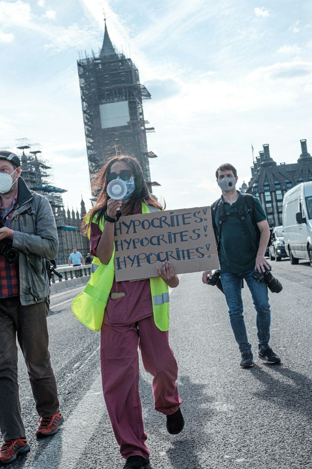 man in green and black jacket holding yellow banner