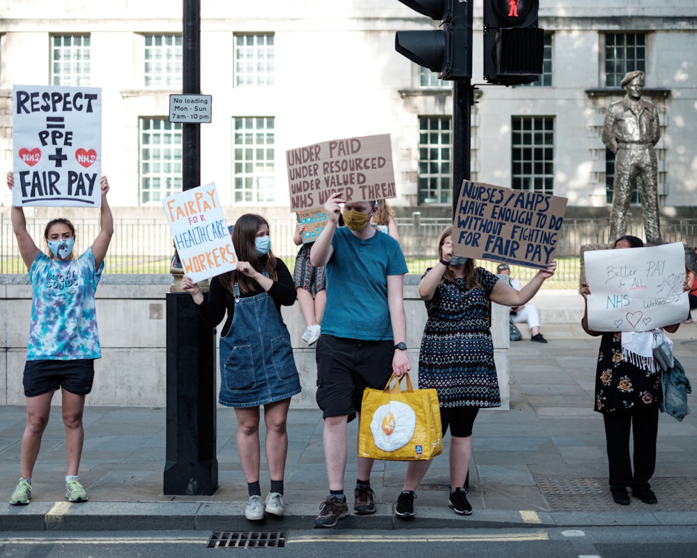 people holding white and blue banner