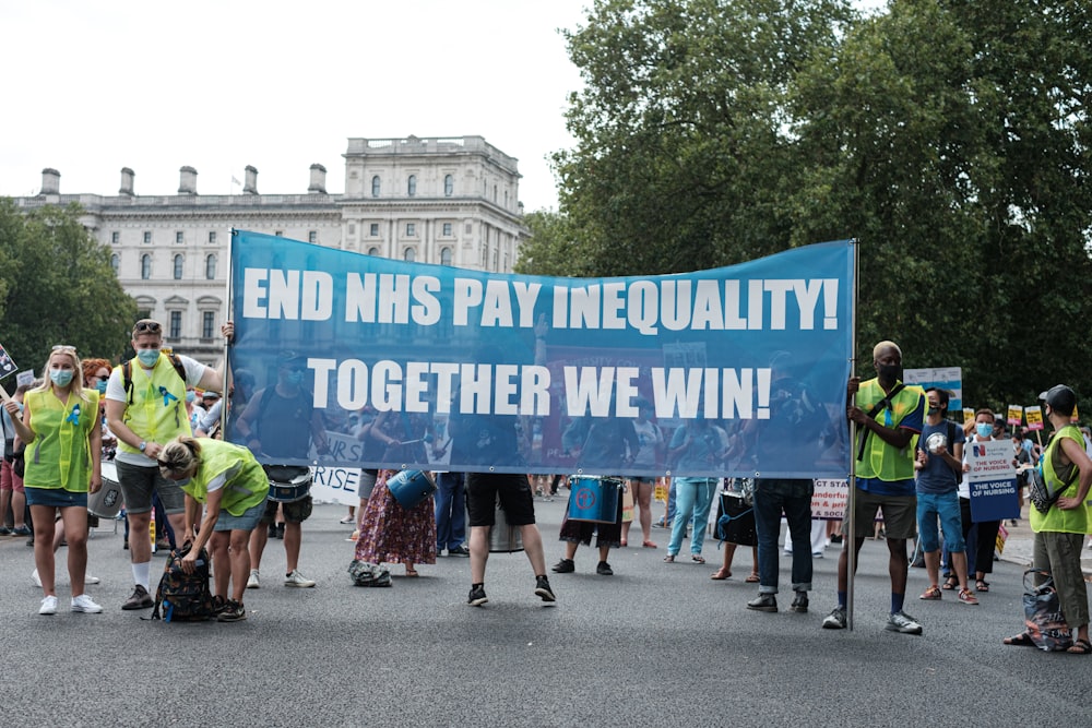 people walking on street with blue and white banner during daytime