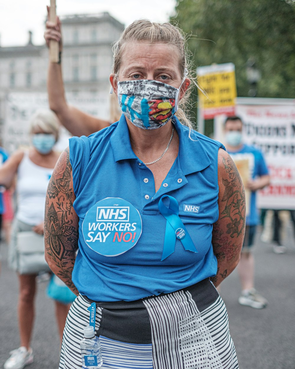 man in blue polo shirt and black and white striped shorts with face paint