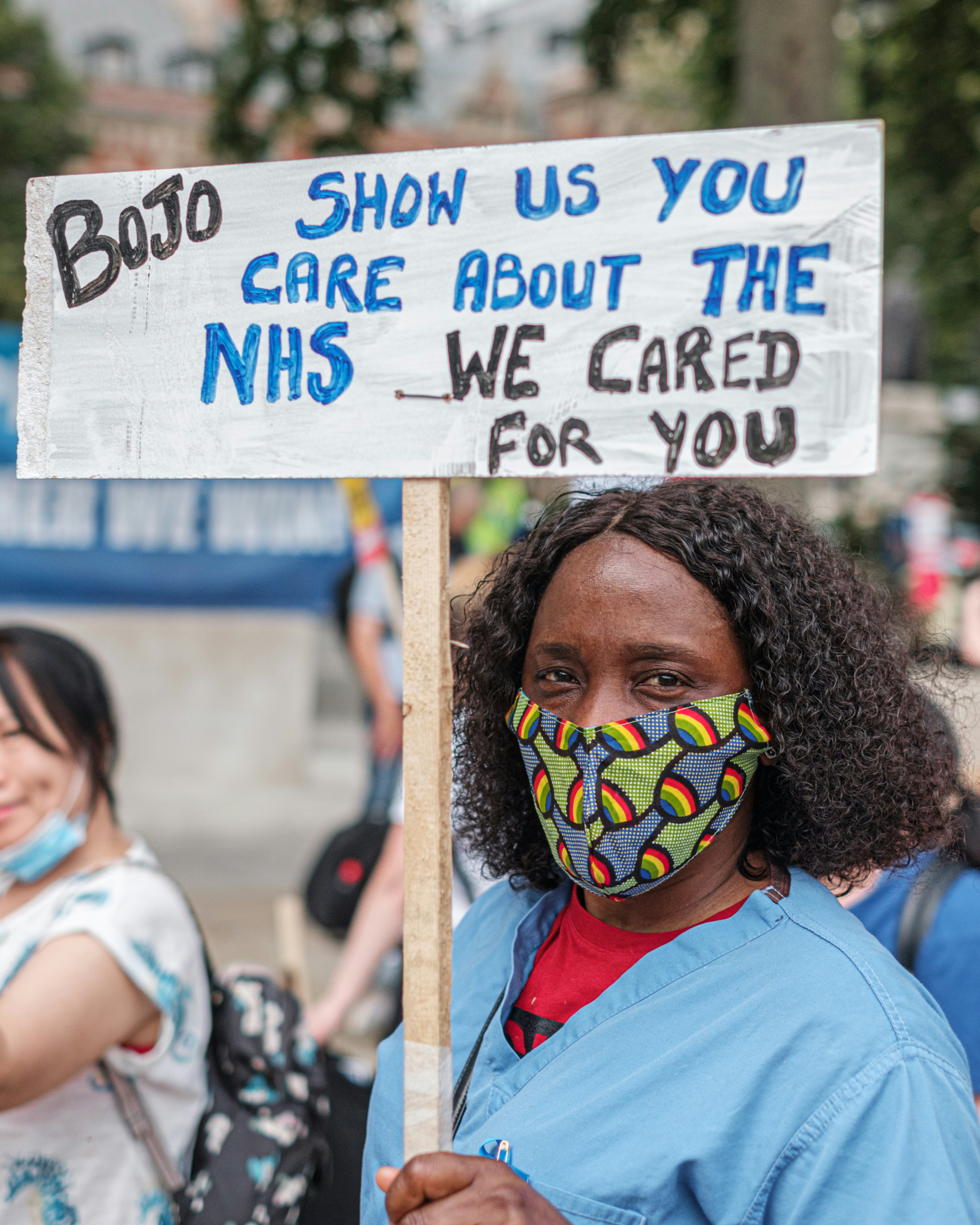 Image of an NHS strike with a sign saying bojo show us you care about the NHS- we cared for you