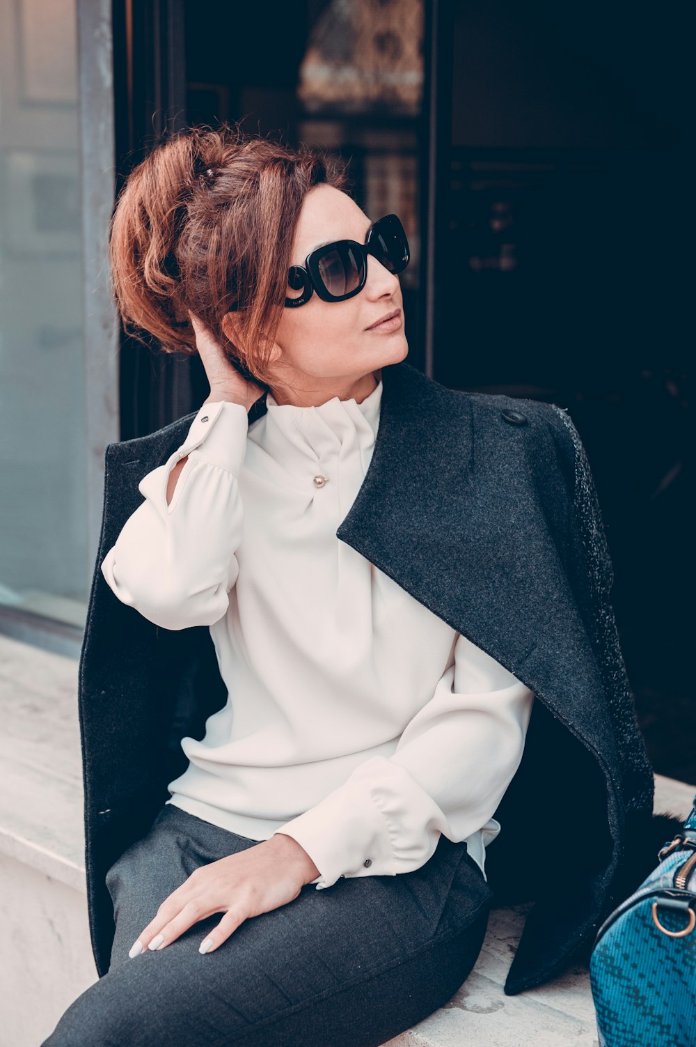 Mujer con abrigo negro con gafas de sol negras