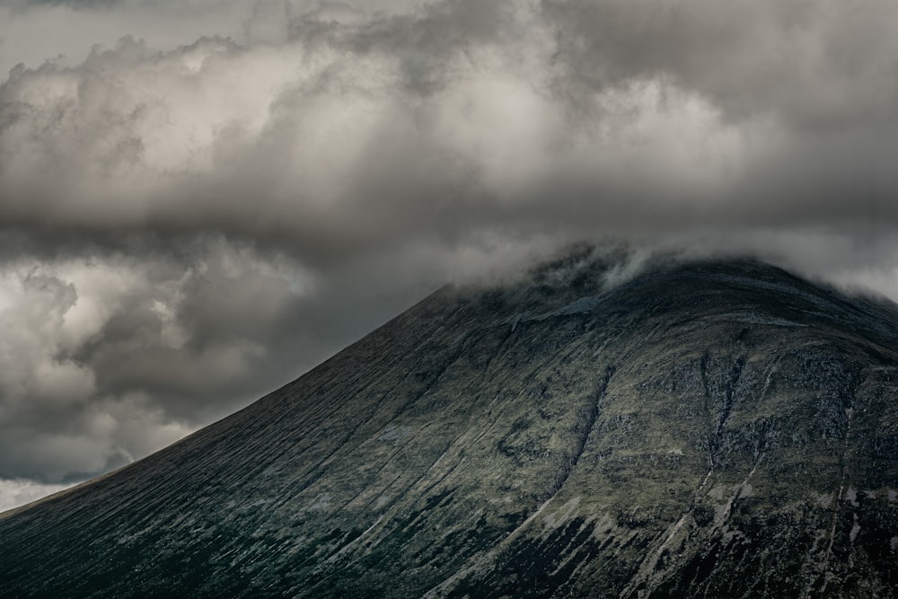 gray and white clouds over green and gray mountain