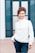 woman in white dress shirt and blue denim jeans smiling