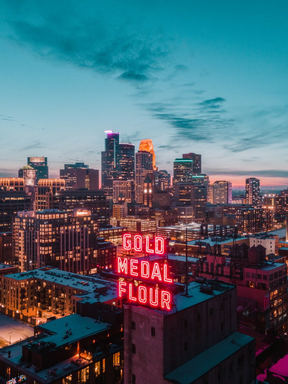 city skyline under blue sky during night time