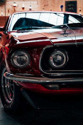 Close-up of a classic car displayed for auction in a well-lit hall.