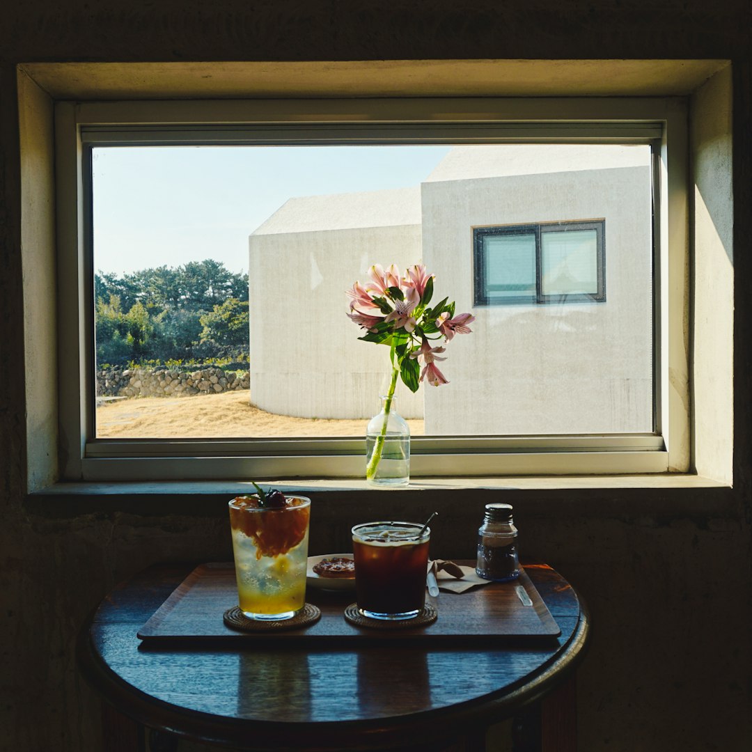 green plant in clear glass cup on brown wooden table