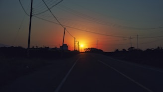 A sunset view of Baja California Sur with power lines silhouetted against the sky.