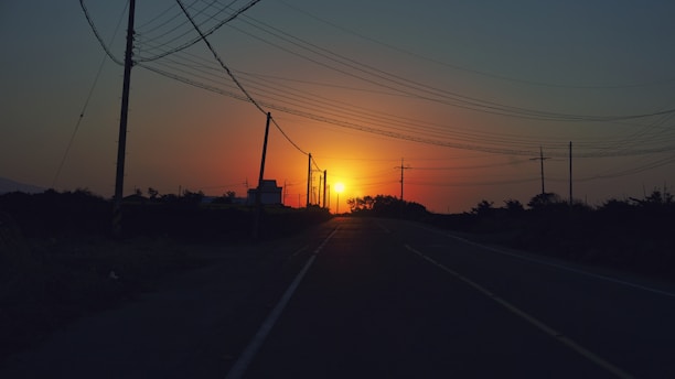 A sunset view of Baja California Sur with power lines silhouetted against the sky.