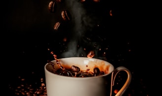 white ceramic teacup with coffee beans