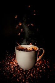 white ceramic teacup with coffee beans